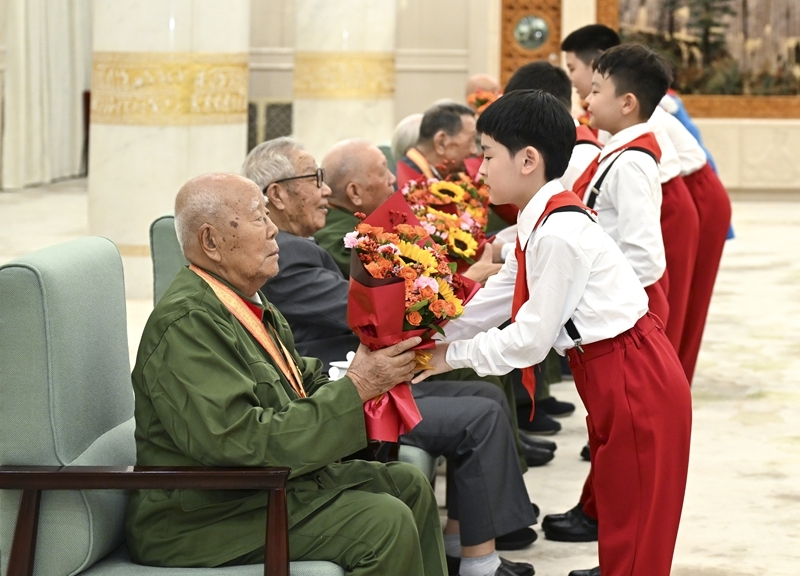 《正义必胜》在北京人民大会堂隆重举行 少先队员向前来观看演出的抗战老战士老同志代表献花